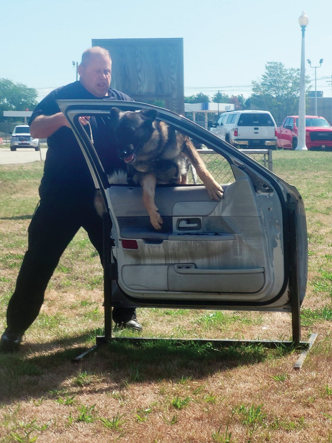 TRAFFIC STOP: Taz leaps through the open window of a car door on the K-9 training course. Dogs in police service face seriously strenuous training that ultimately takes a toll on their bodies. Taz has been training for duty since he was just a few months old.